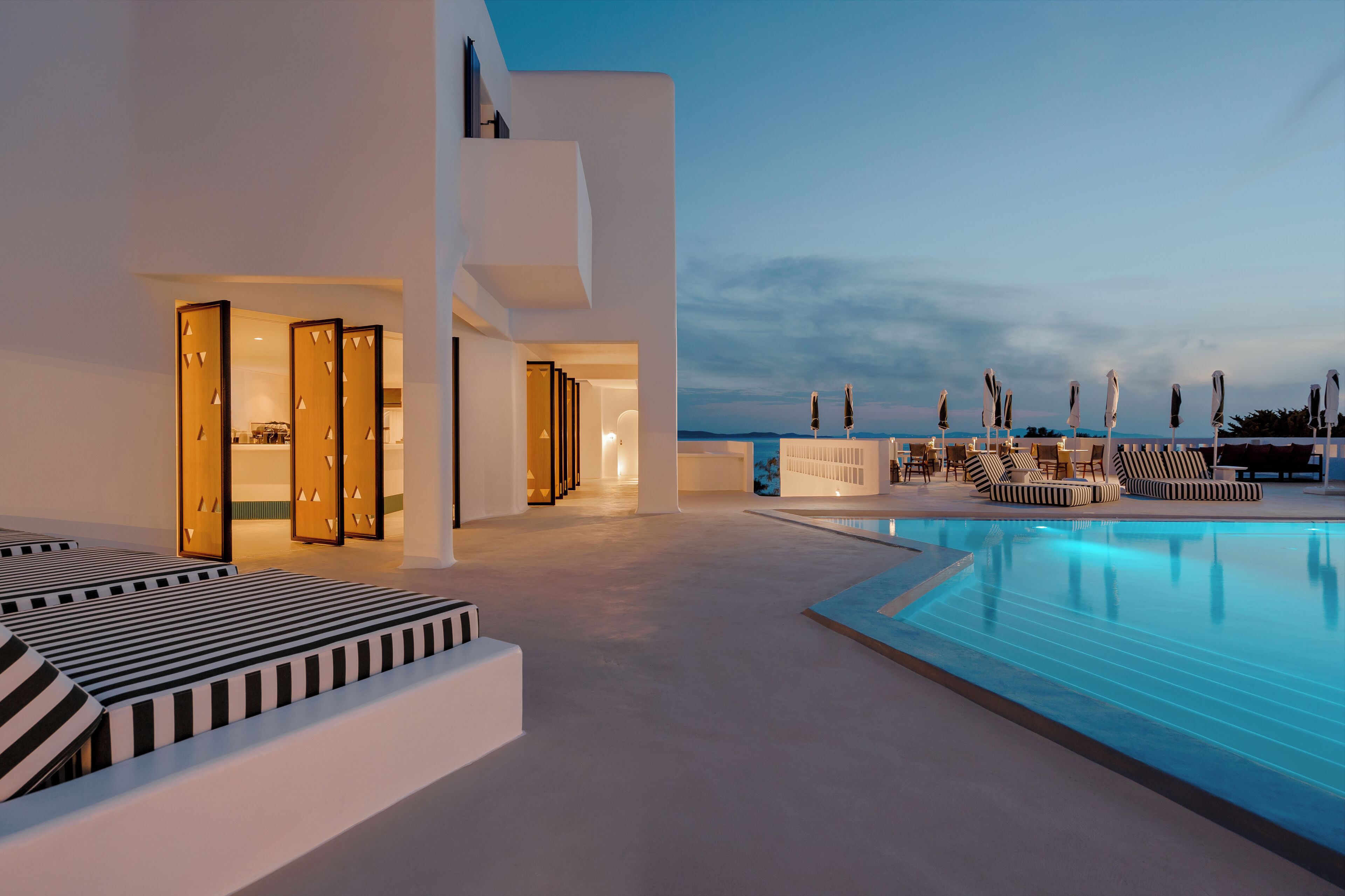 A modern pool area with lounge chairs and a clear view of the sky.