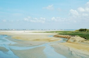 Enjoy a serene coastal escape with access to a wide sandy beach and lush grassy dunes.