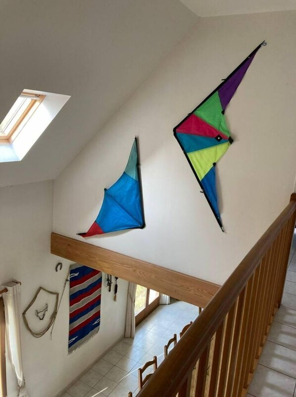A staircase with a wooden handrail and a skylight above.