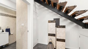 Une salle de bain moderne avec un lavabo blanc, un porte-serviettes et une cabine de douche en verre.