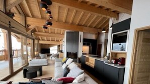 Un interior moderno con sala de estar, cocina y ventanas amplias.