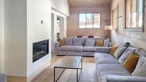 Ein geräumiges Wohnzimmer mit einer großen Eckcouch, einem Couchtisch und einem Kamin.