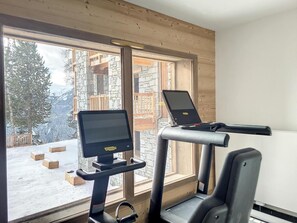A gym with exercise equipment and a computer monitor, large windows with a view of snow-covered mountains. - View mountain, fitness, sauna, balcony, parking, tv, ski locker, 126m², La Rosière (Montvalezan)