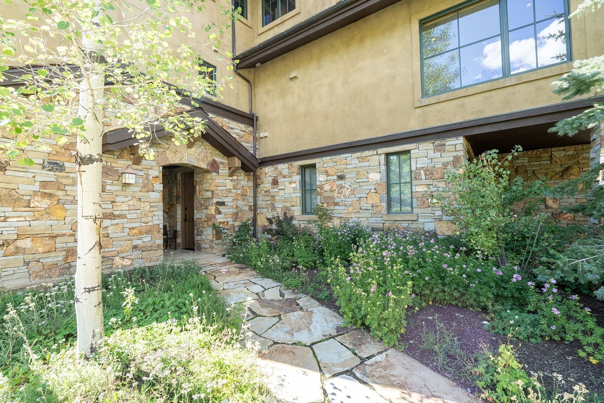 A stone house with a stone pathway leading to a wooden door.