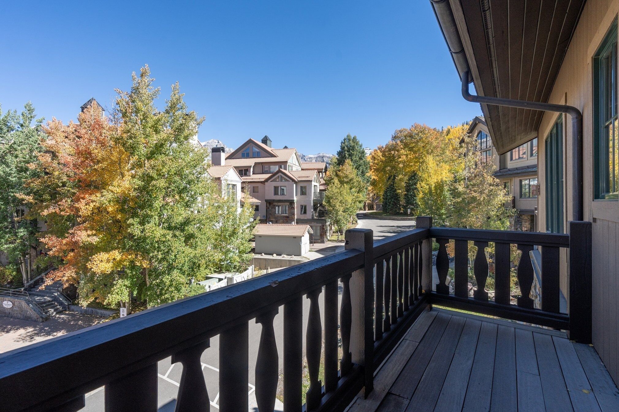 A balcony with a view of residential buildings and autumn trees.