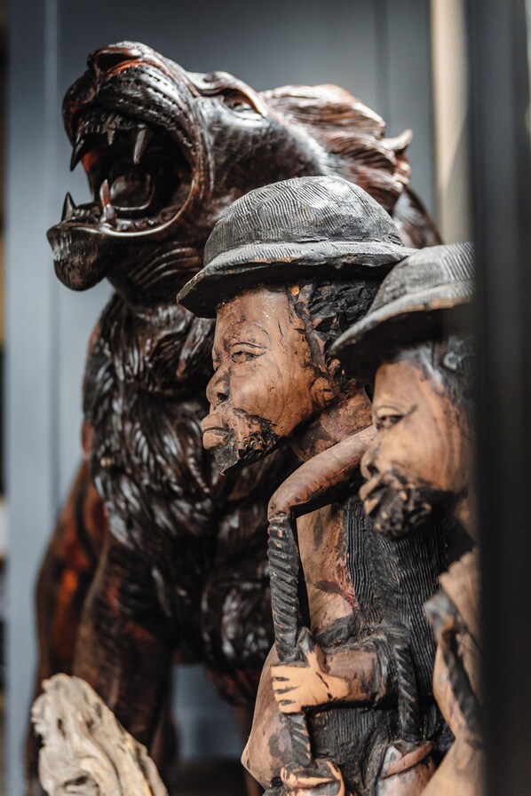 A wooden sculpture of a figure with a hat and a child. - Grace of Africa (Nkomazi)