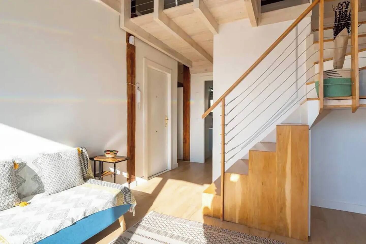 Ein modernes Interieur mit Treppe, einer Couch und einem kleinen Tisch.