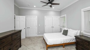 A bedroom with a bed, two wardrobes, a ceiling fan, and a window with blinds. - Near UC + Cincinnati Zoo 3BR Sleeps 10 (Cincinnati)