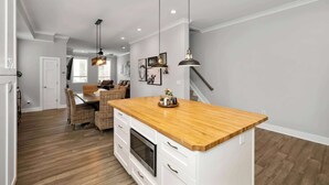 A modern kitchen with a wooden countertop, white cabinetry, and pendant lighting. - Near UC + Cincinnati Zoo 3BR Sleeps 10 (Cincinnati)
