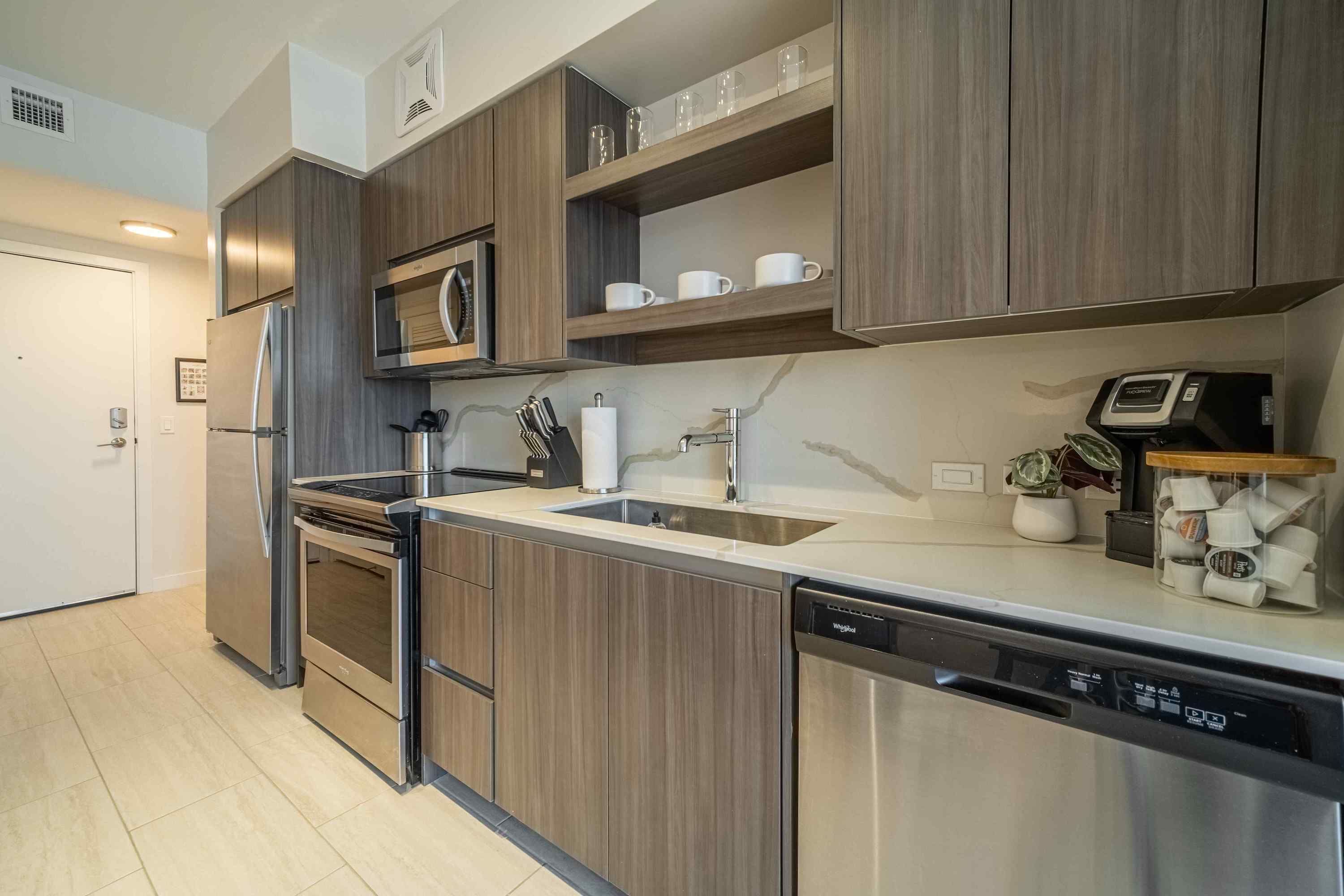 Una cucina moderna con elettrodomestici in acciaio inossidabile, mobili in legno e forno a microonde integrato.