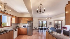 A modern kitchen with wooden cabinets, stainless steel appliances, and a central island. - Villa Korona - Three Bedroom Villa, Sleeps 6 (Neo Chorio)