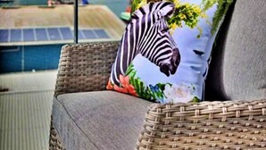 A wicker chair with a cushion featuring a zebra design, positioned on a balcony with a view of a river and distant landscape. - Anchor View (Teignmouth)