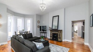 A modern living room with a sectional sofa, a fireplace, and a chandelier.