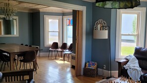 Una habitación con una mesa de comedor y sillas, un sofá de cuero y un tablero de ajedrez.