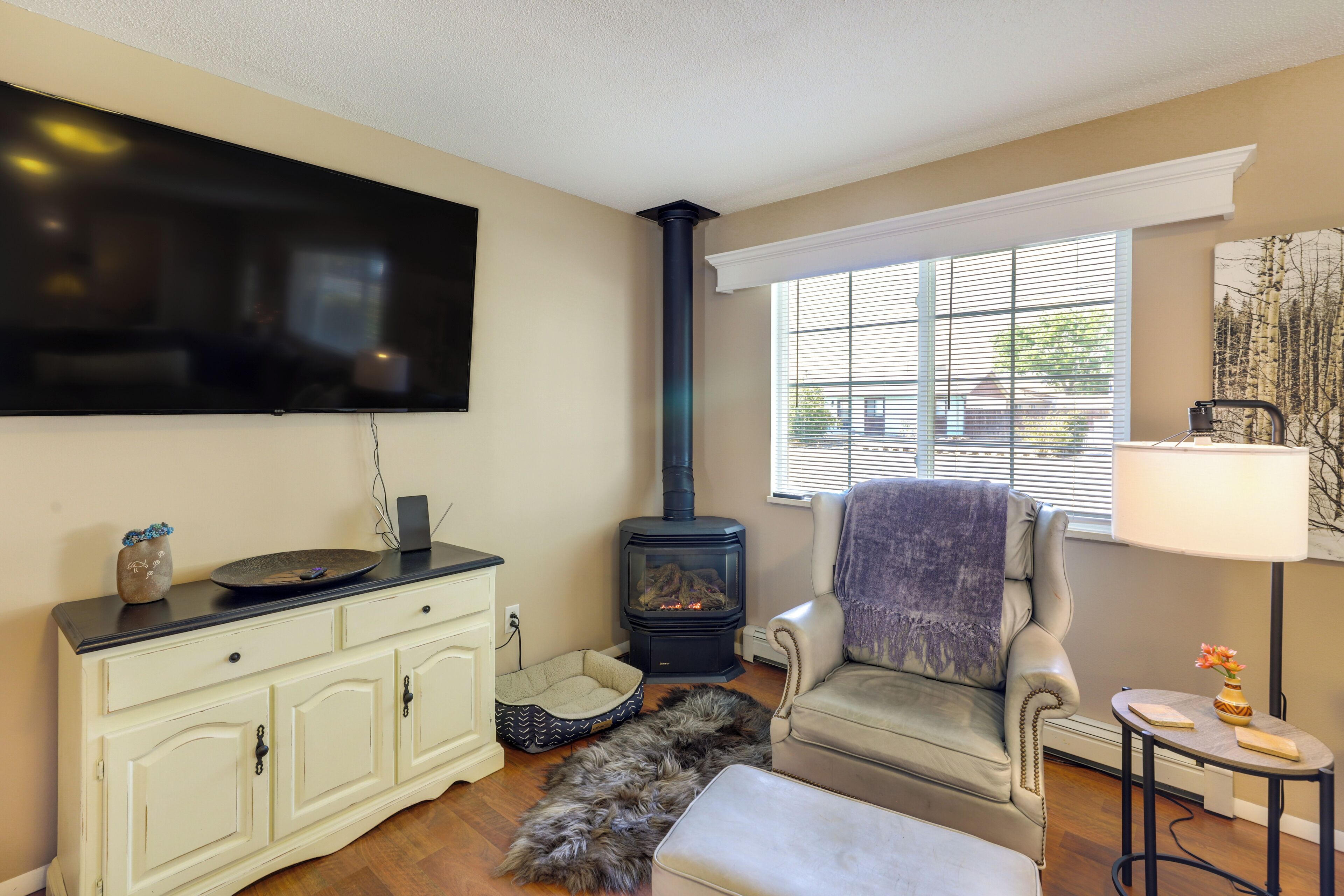 A living room with a fireplace, a sofa, a TV, and a lamp.