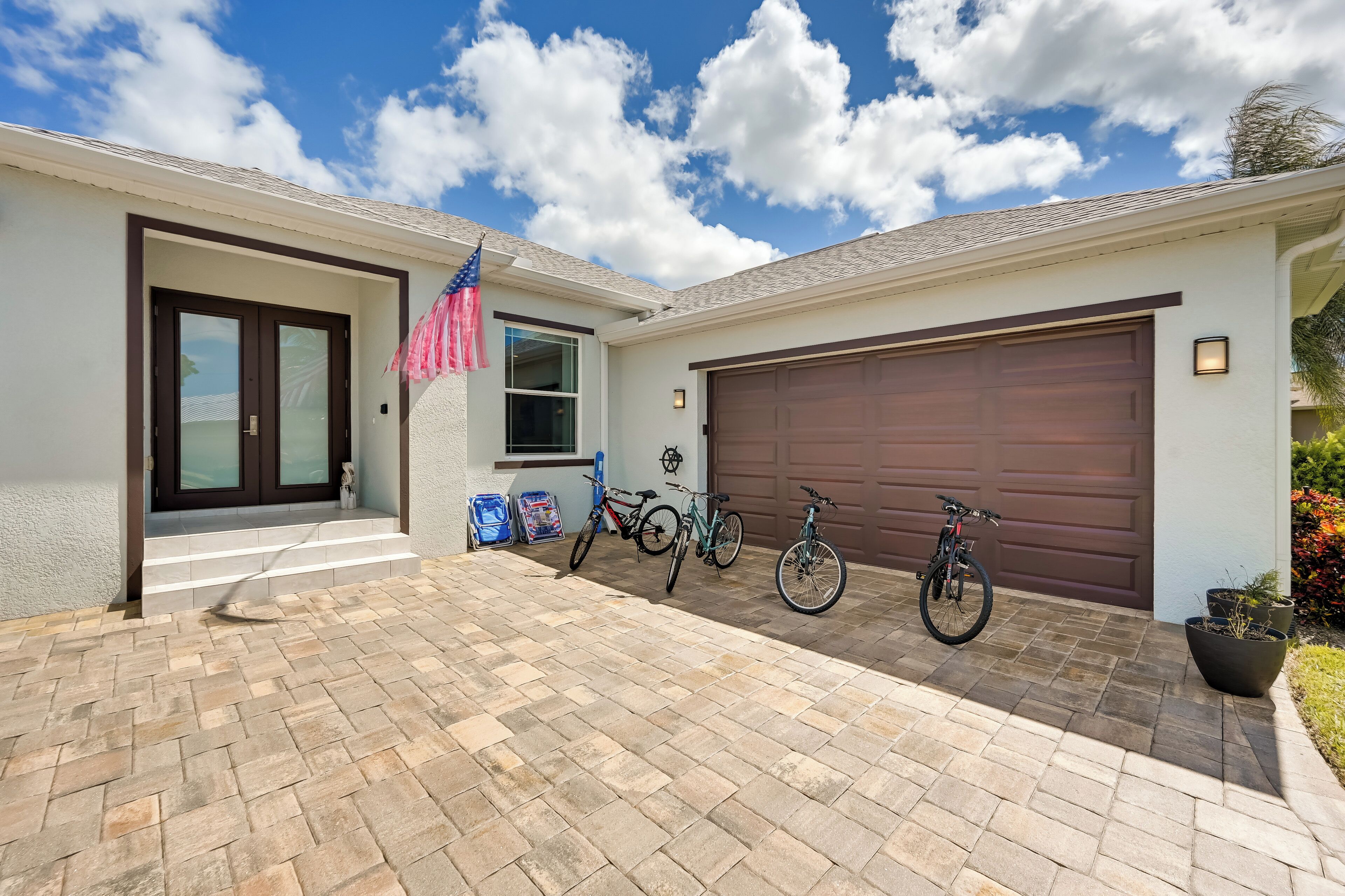 Een modern huis met een garage, een voordeur en een oprit met fietsen.
