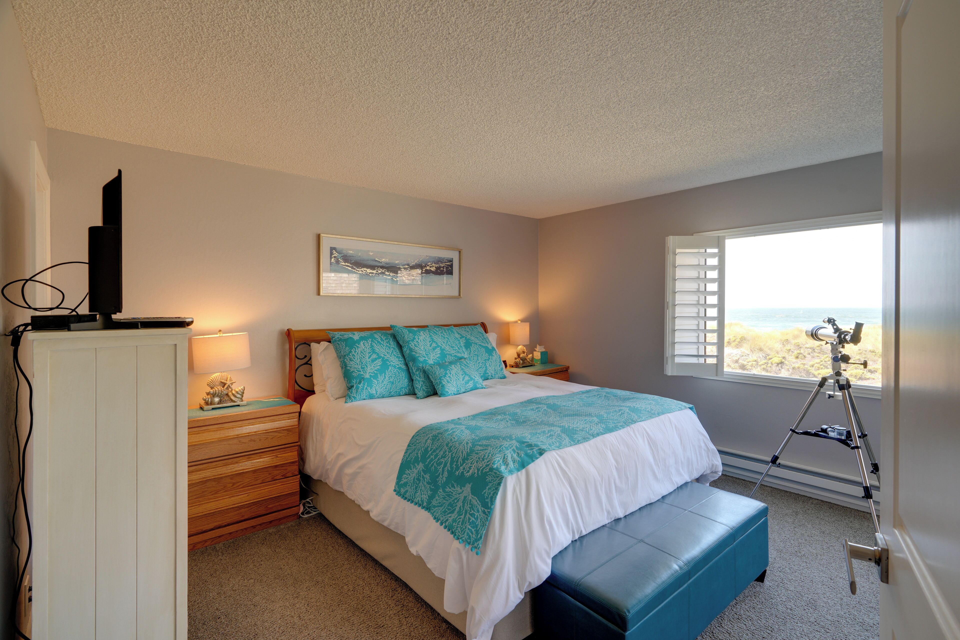 A bedroom with a bed, a nightstand, a dresser, a window with a view, and a telescope.