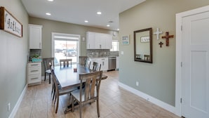 A spacious kitchen with a dining area, white cabinetry, and a large mirror on the wall. - Bright, Modern Corpus Christi Condo: 2 Mi to Beach (Corpus Christi)