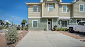 A two-story residential building with a driveway and a parked truck. - Bright, Modern Corpus Christi Condo: 2 Mi to Beach (Corpus Christi)