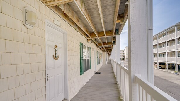 A corridor with white tiled walls, green-framed windows, and a wooden ceiling. - Oak Island Vacation Rental ~ 1 Block to Beach! (Oak Island)