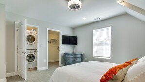 A bedroom with a bed, a washing machine, a dresser, a television, and a window with blinds. - Updated Home - Walk to Salisbury University! (Salisbury)