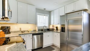 A modern kitchen with white cabinets, stainless steel appliances, and a granite countertop. - Updated Home - Walk to Salisbury University! (Salisbury)