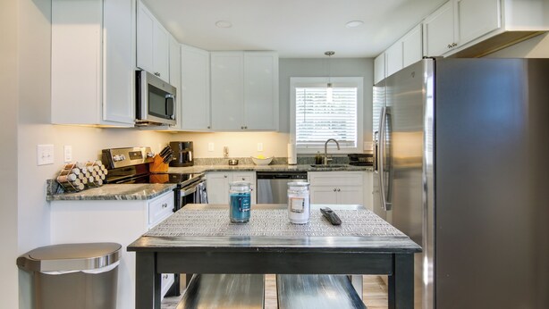 A modern kitchen with white cabinets, stainless steel appliances, and a granite countertop. - Updated Home - Walk to Salisbury University! (Salisbury)