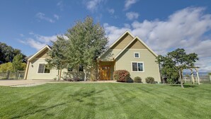 A two-story house with a well-maintained lawn, a front porch, and a large tree. - Pet-friendly Stevensville Home w/ Mountain Views! (Stevensville)