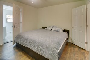 Ein Schlafzimmer mit einem Bett, Holzboden und weißen Türen.