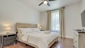 A neatly arranged bedroom with a bed, bedside tables, a ceiling fan, and a dresser. - Charming Navarre Townhome: 5 Mi to Beach! (Navarre)