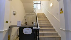 Una escalera con un letrero que indica apartamentos del 01 al 04, del 05 al 08 y del 09 al 15.
