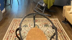 Een woonkamer met een open haard, een televisie, een bank en een schommelstoel.