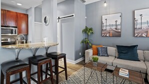 A modern living room with a sofa, coffee table, and artwork on the wall. - Downtown Chattanooga Loft in the Heart of the City (Chattanooga)