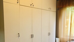 Une chambre à coucher avec une grande armoire, un lit et une commode.