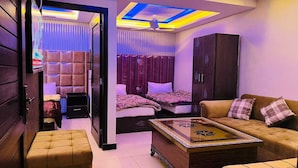 A modern bedroom with a sofa, two beds, a cabinet, and a ceiling light fixture. - Hotel 11 (Islamabad)