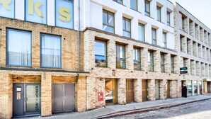 Un edificio moderno con facciata in mattoni, ampie finestre e un cartello per una galleria.