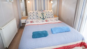 Une chambre à coucher avec un lit, une fenêtre, un radiateur et un miroir.