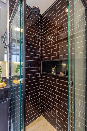 Panorama studio | Badkamer | Een douche, een haardroger, handdoeken, zeep
