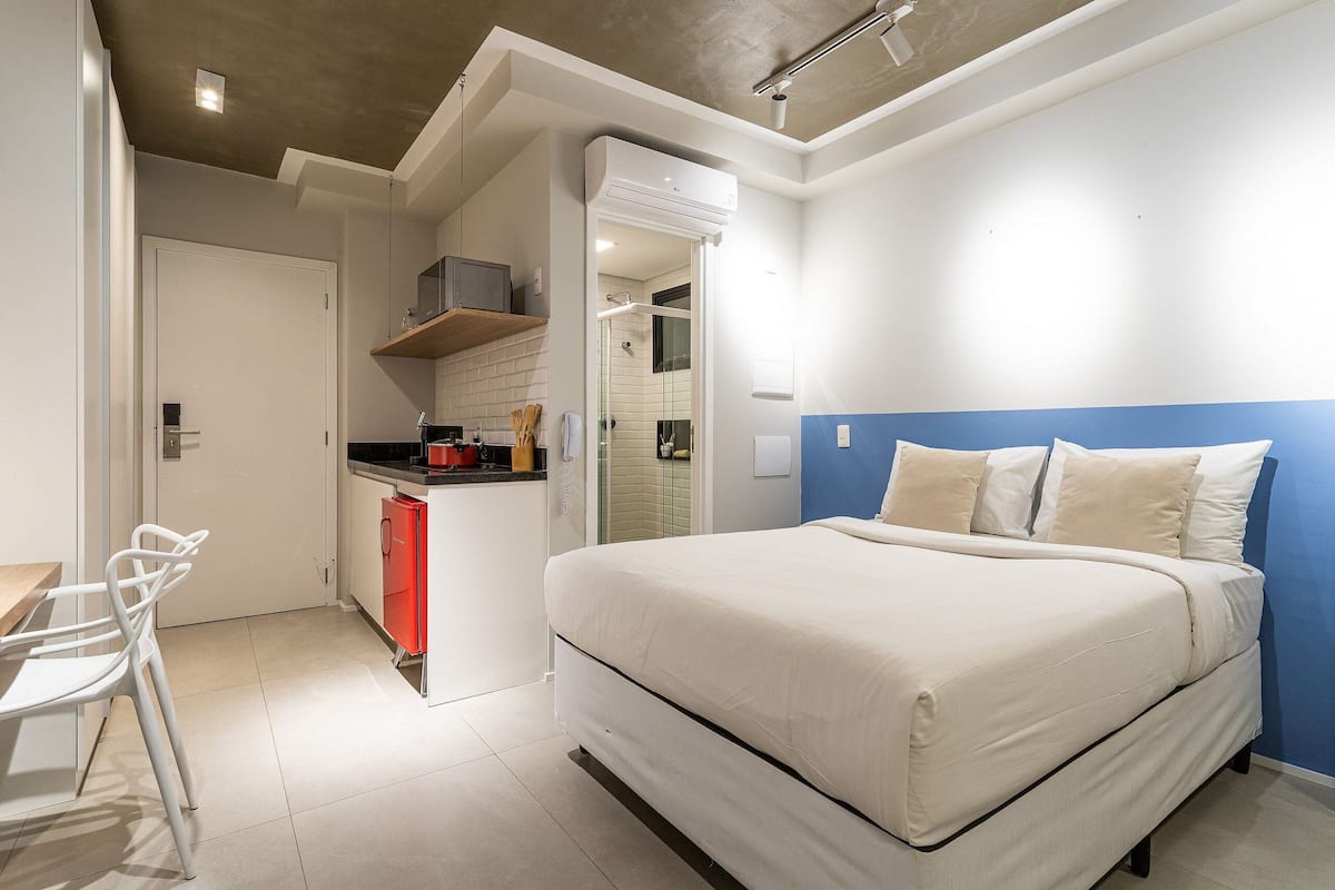 A bedroom with a bed, a desk, and a chair.