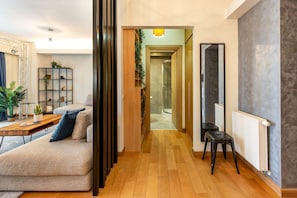 Relax in this inviting living space with a sofa, coffee table, and shelving unit, surrounded by natural beauty.