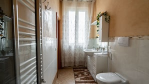 Ein Badezimmer mit Toilette, Waschbecken und Duschbereich.