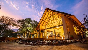 A modern house with a large open porch, a dining area, and a visible kitchen. - Cape Vulture Lodge (Hoedspruit)