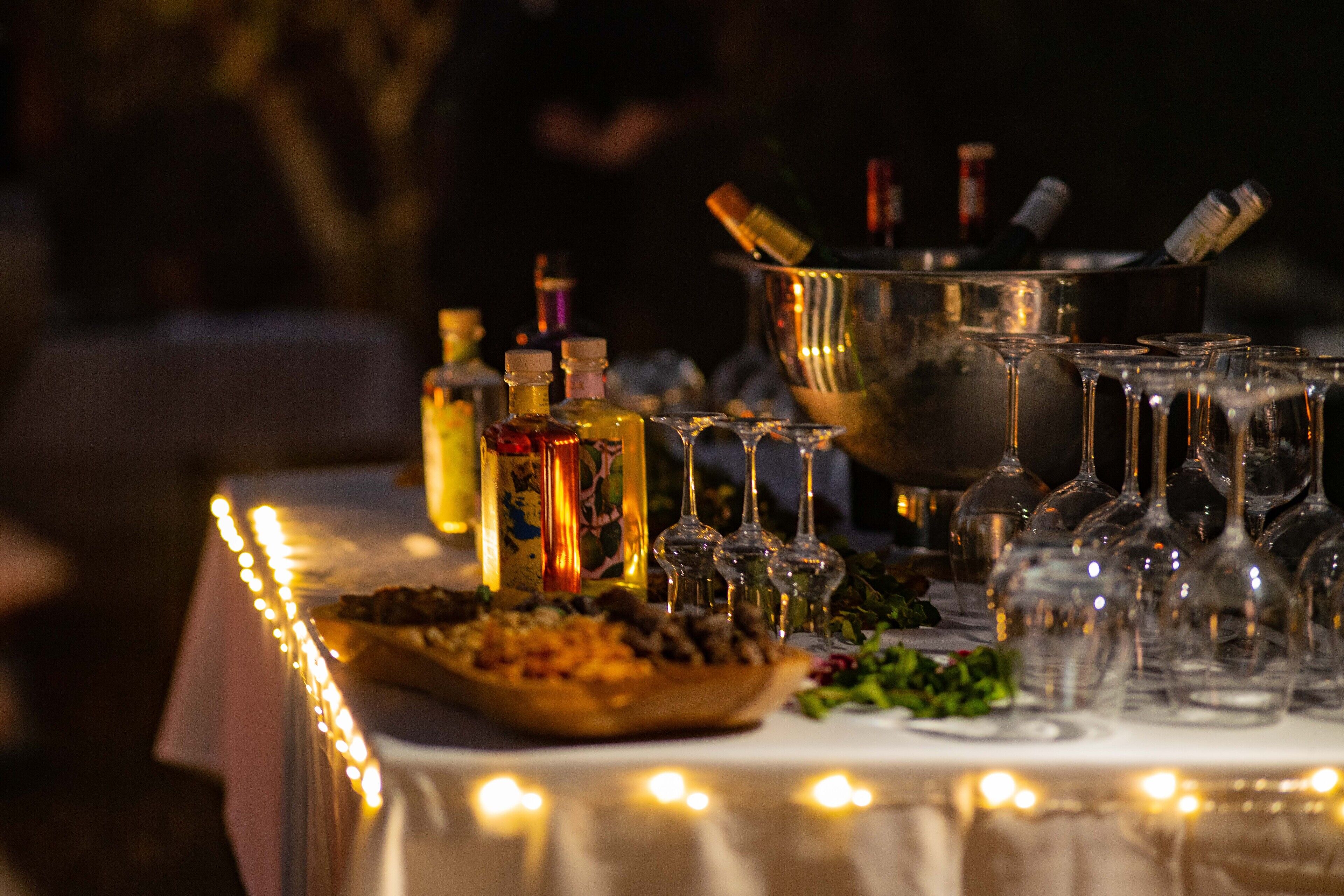 A table set for a formal event with a variety of glassware, bottles, and a centerpiece.