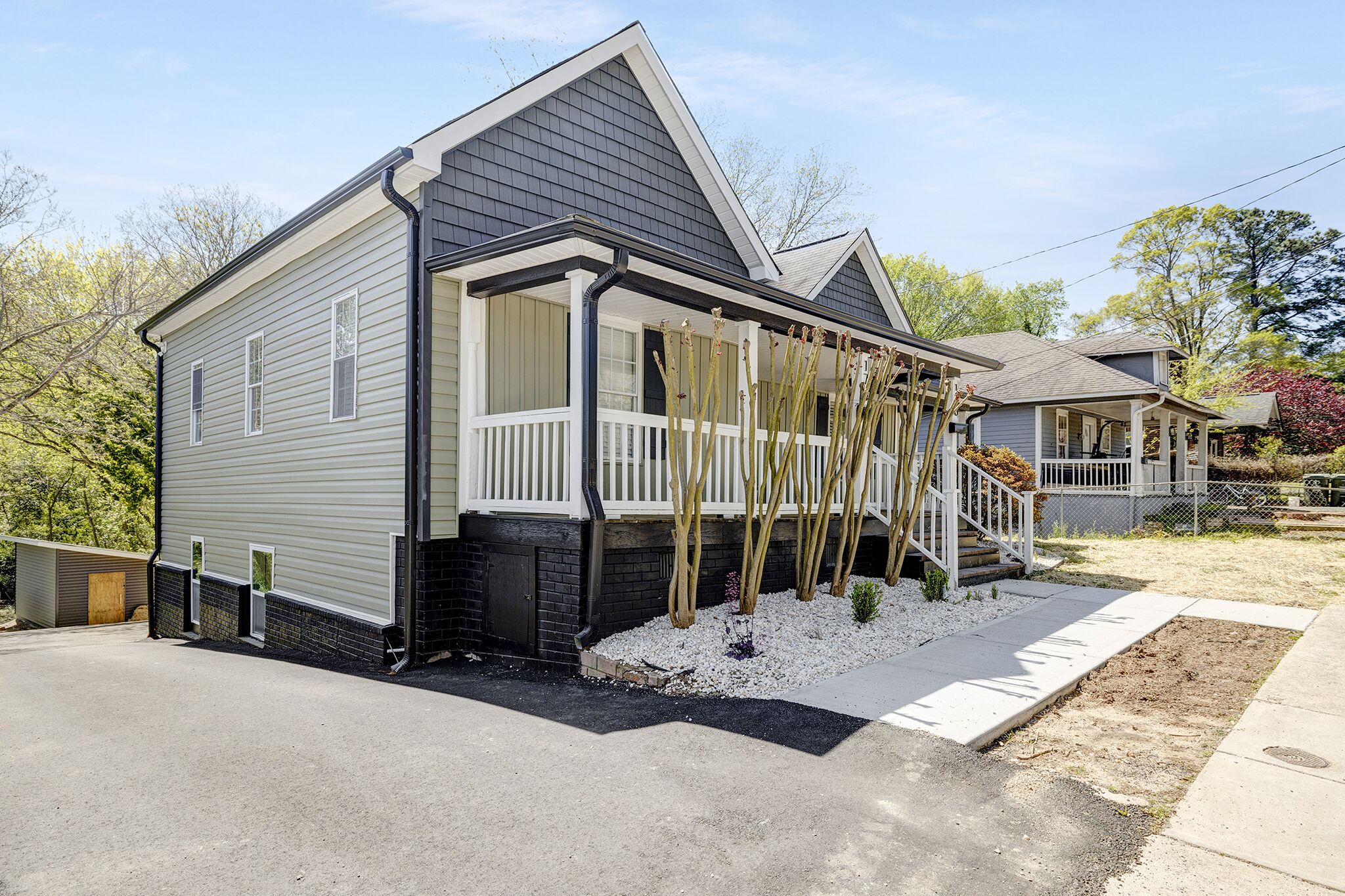 A two-story house with a covered porch and a small front yard.