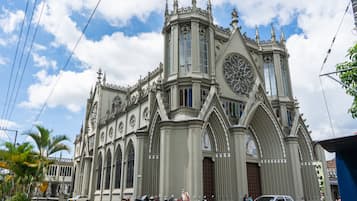 Una iglesia grande y ornamentada con una imponente torre de reloj y varios ventanales de arco.