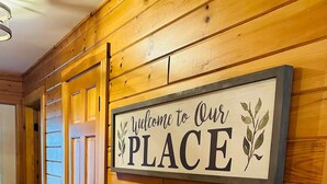A hallway with wooden paneling and a sign that reads "Welcome to Our PLACE".