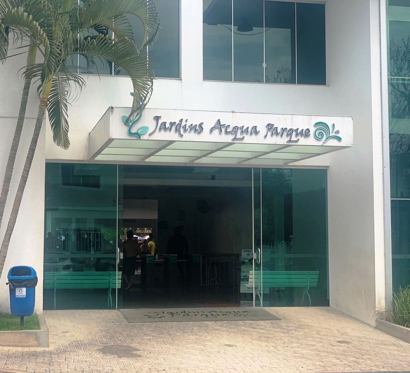 Un edificio con un letrero que dice "Jardins Acqua Parque" y una entrada de vidrio.