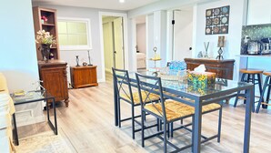 A dining area with a glass table, black chairs, and a wooden cabinet.