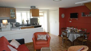 A compact living space with a kitchen, dining area, and seating area. - Cottage Kerruer (CHERRUEIX)