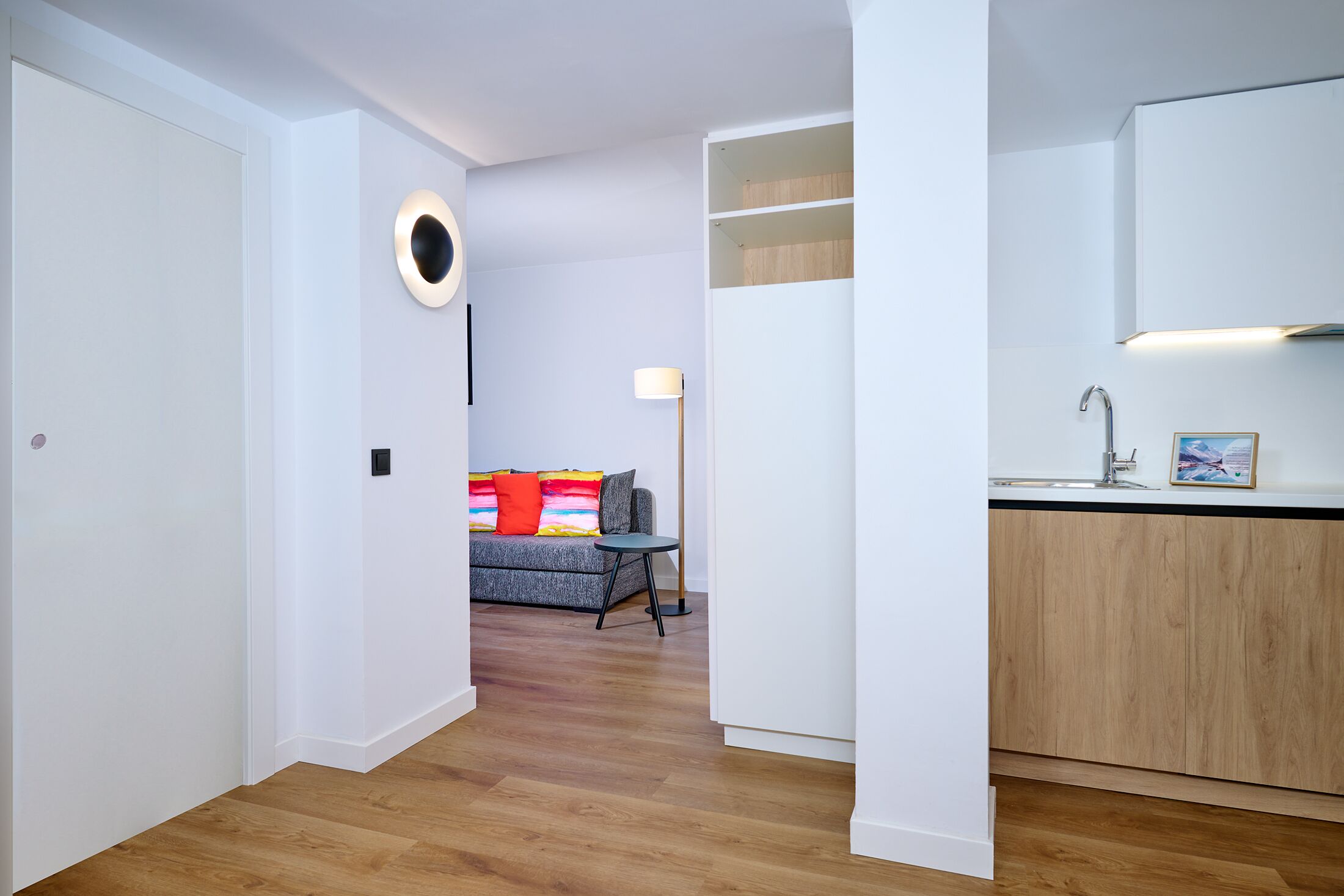 Un apartamento moderno con un pasillo que conduce a una sala de estar y una cocina.